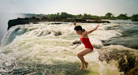 Девушки купаются у самого края водопада Виктория в Замбии