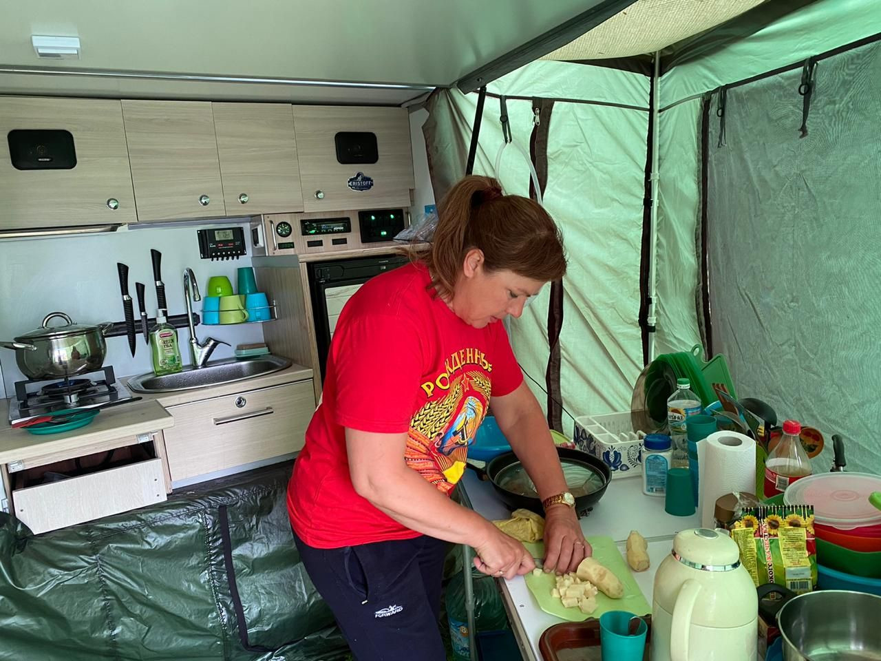 Татьяна за приготовлением ужина в нашем прицепе – фотографии России