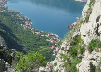 Турист на скале Которского залива, Черногория – фотографии Черногории