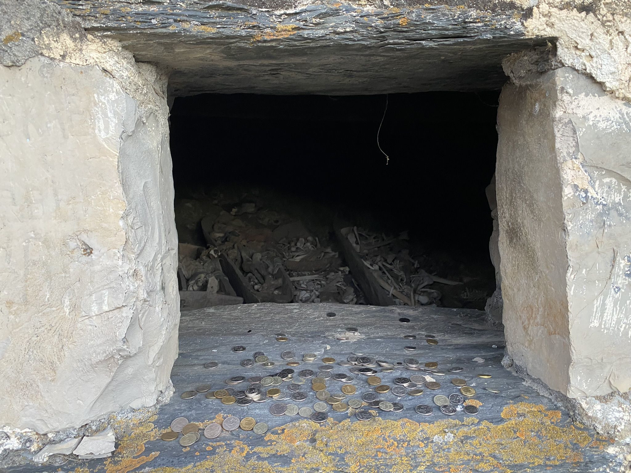 Монетки в окошках склепа Даргавса - города мертвых в Северной Осетии, Россия – фотографии России