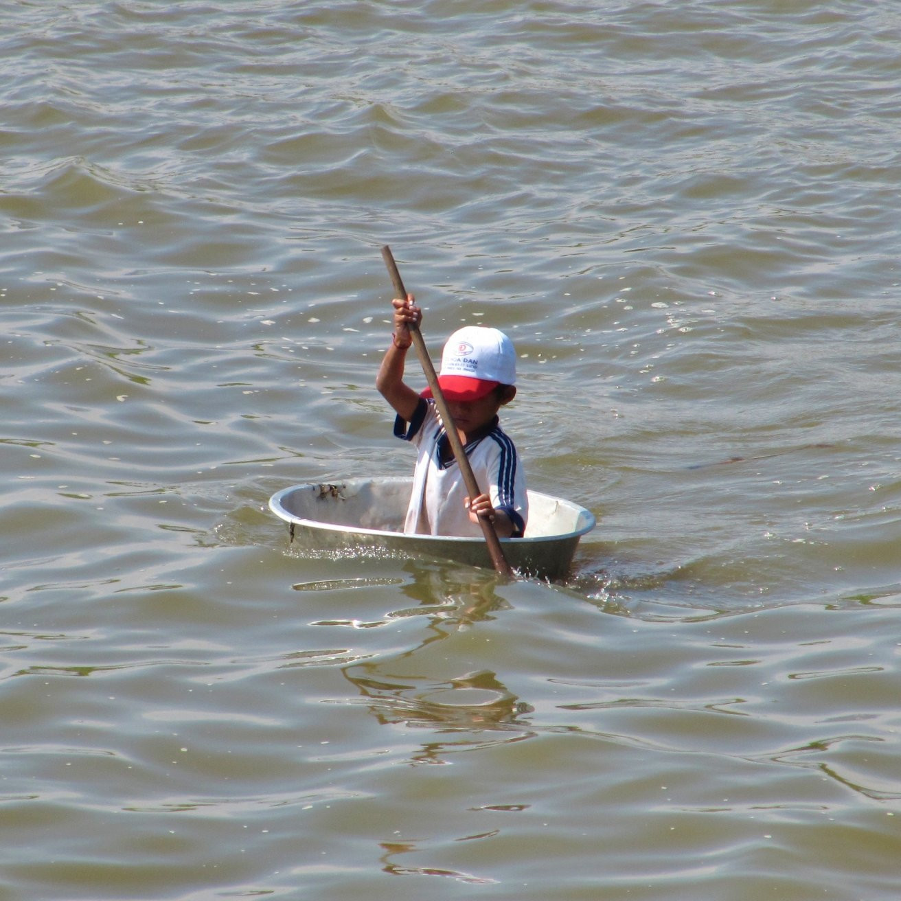 Ребенок в тазу на озере Топлесап, Камбоджа – фотографии Камбоджи