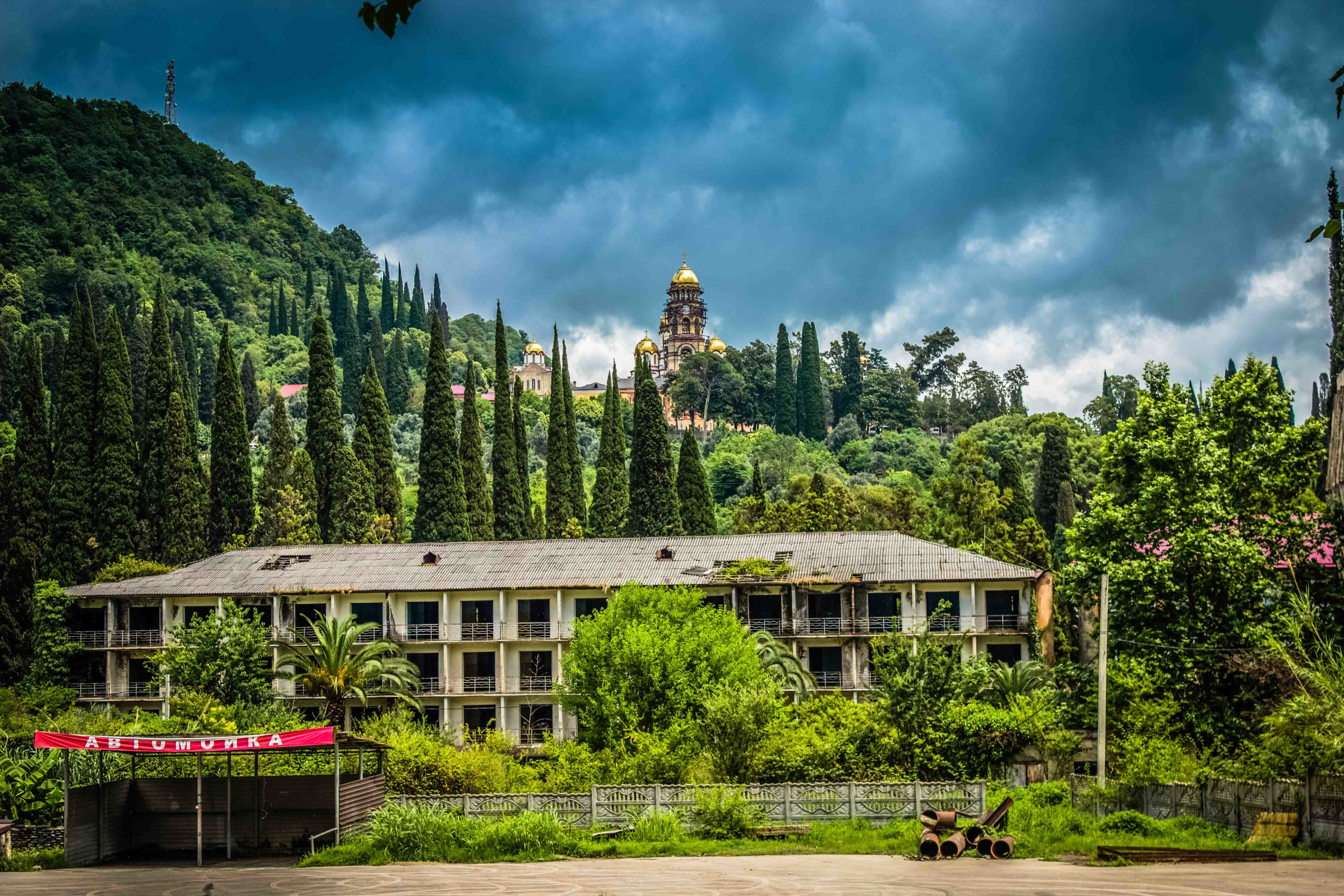 Заброшенное здание на фоне Новоафонского монастря. Новый Афон – фотографии Абхазии
