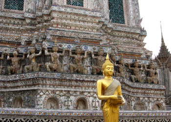 Статуя стоящего будды на фоне храма – фотографии Таиланда