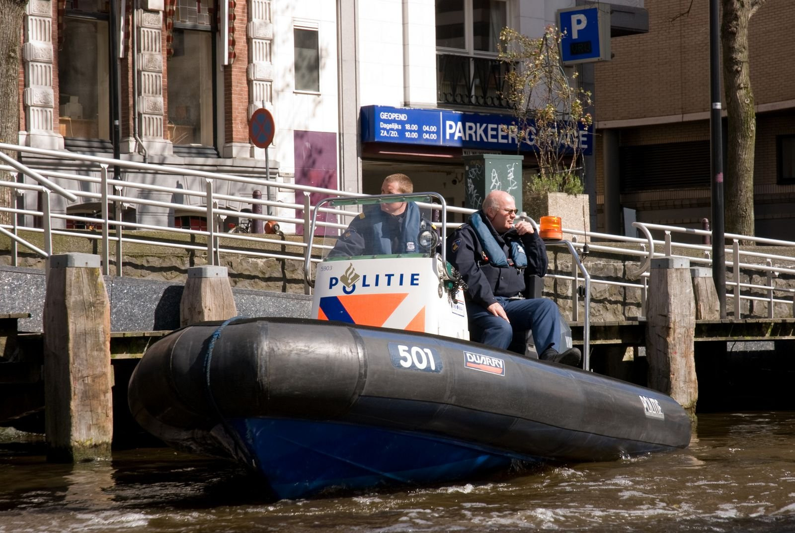 Полицейский катер на канале реки в Амстердаме, Нидерланды – фотографии Нидерландов