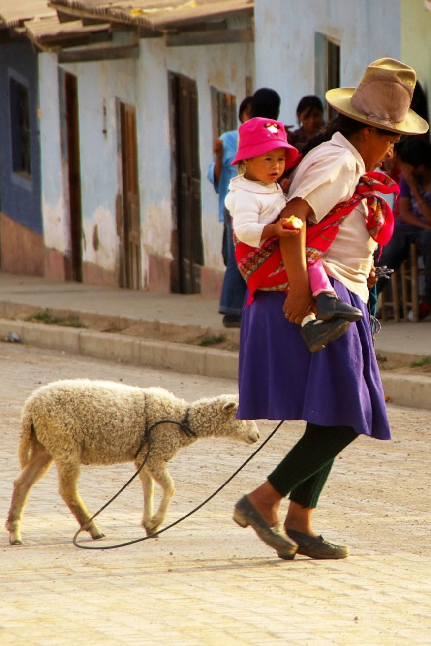 Женщина с ребёнком и овечкой на поводке, Перу – фотографии Перу