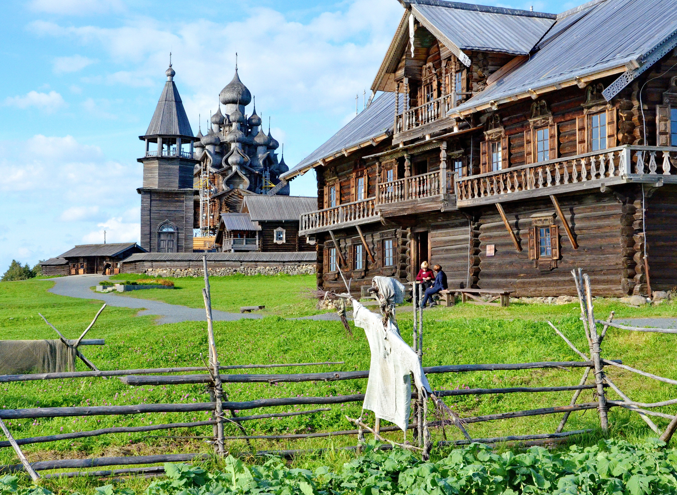 В комплексе архитектурного ансамбля Кижи центральное место занимают 2 церкви и колокольня с забором – фотографии России