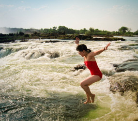 Девушки купаются у самого края водопада Виктория в Замбии